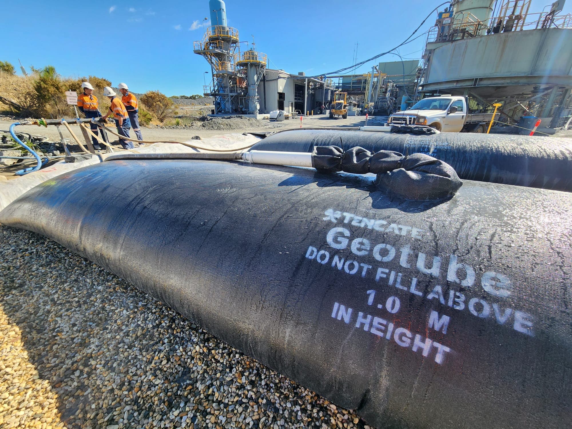 Workers preparing and filling GEOTUBE® units with sludge waste for dewatering at the gold mine, using GT 500D and GTL 500D wicking technology. 